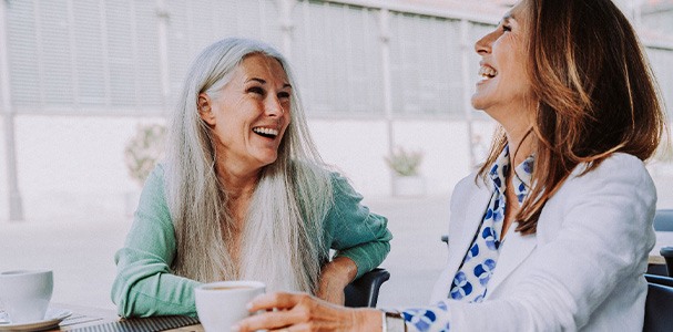 Two women smiling while enjoying coffee together