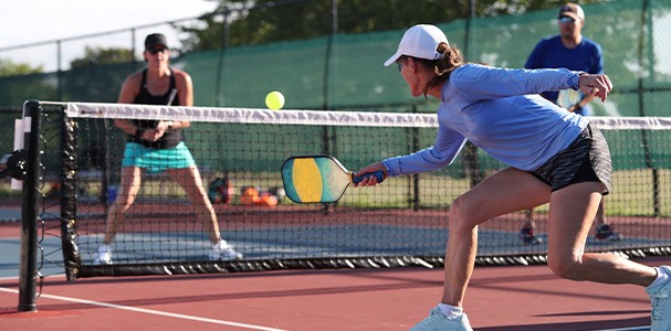 Closeup of people playing tennis on sunny day