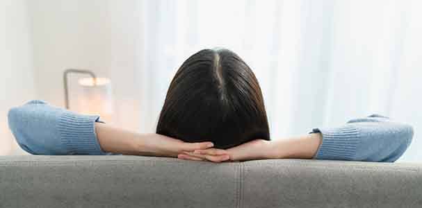 Back view of woman relaxing on couch